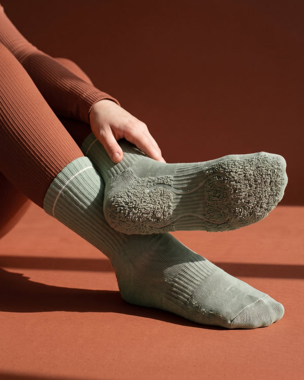 Sage Mist: meia de Pilates do avesso, laçadas de felpa espessas sob todo o pé e duas tiras de silicone transparente no interior