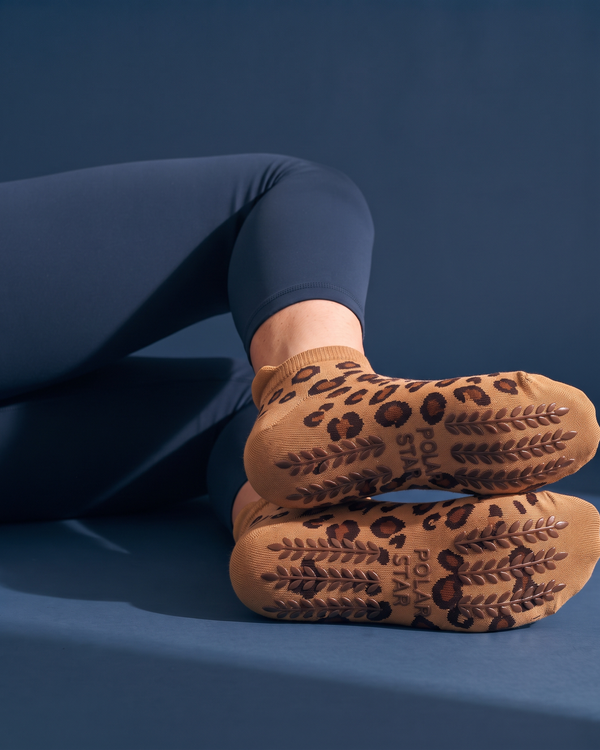 Savanna: solas com padrão leopardo, grips de silicone antiderrapantes castanho-escuro em forma de espiga e logótipo Polar Star em relevo, fundo azul-marinho