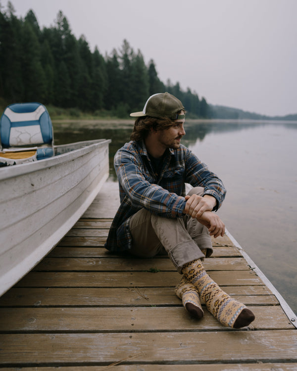 Arild nordic socks worn indoors, one bare leg and one leg in jeans and a boot