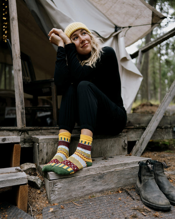Svea nordic socks worn with leather boots, standing on stones in a stream