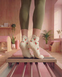 Sur la pointe des pieds sur un reformer, chaussettes Cherry Blossom crème à cerises, vue de dos