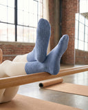 Semelles bleu jean des chaussettes Stone Blue, jambes levées, picots de grip haute densité