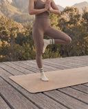 Posture de l'arbre en terrasse, chaussettes Polar Star x Maison Matcha blanches à rayures vertes