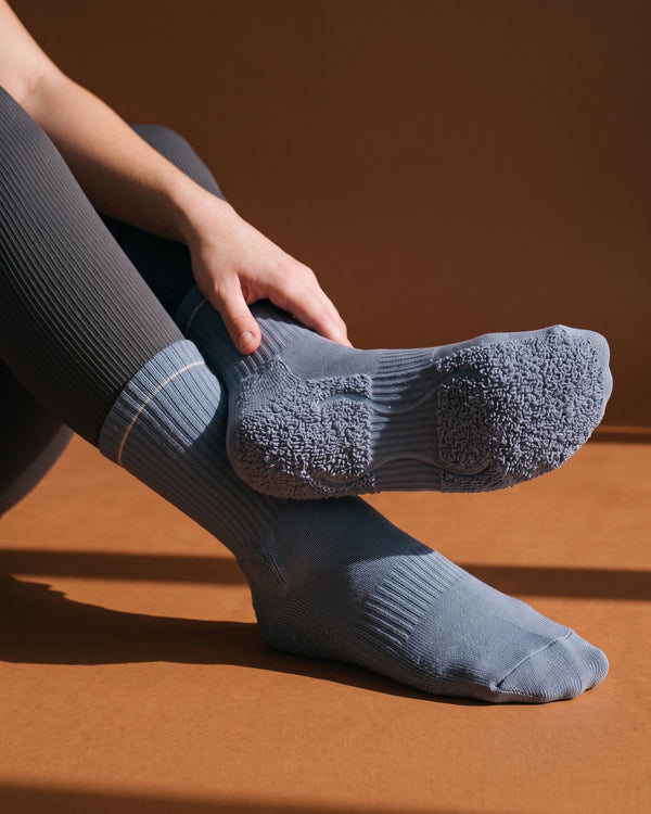 Stone Blue: meia de Pilates do avesso, laçadas de felpa espessas sob todo o pé e duas tiras de silicone transparente no interior