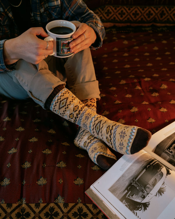 Arild nordic socks worn indoors, overhead view with cups of coffee and biscuits
